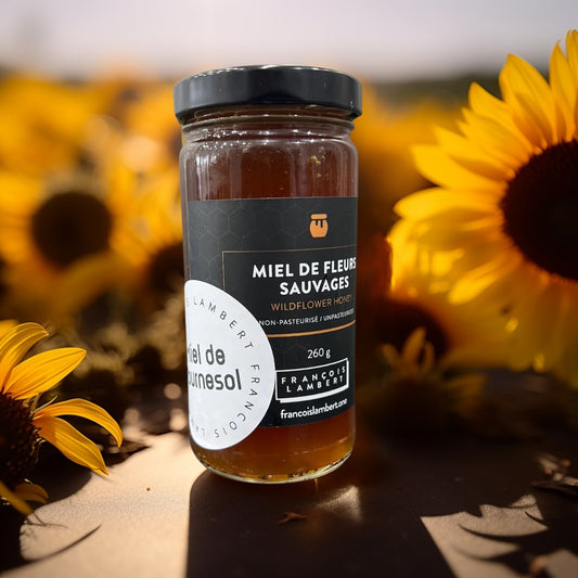 Miel de tournesol sur une table entouré de fleurs